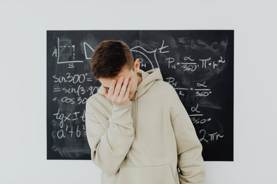 boy upset with math chalkboard behind him